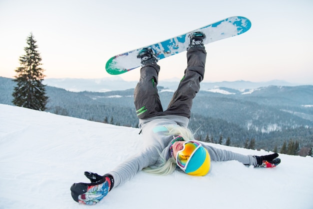 Female snowboarder on slope in mountains