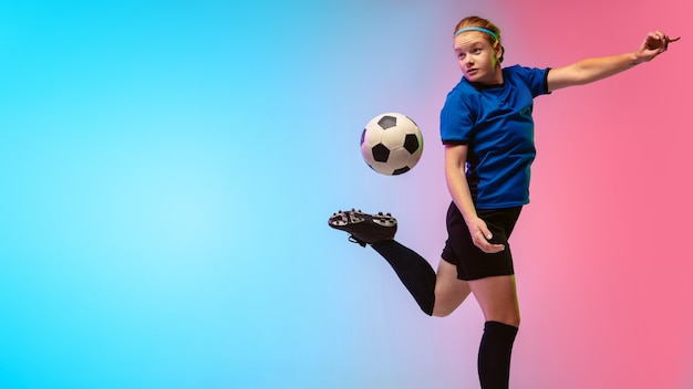 Female soccer, football player training on neon wall, youth