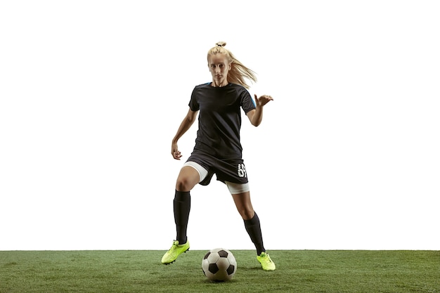 Photo female soccer player kicking ball at the stadium