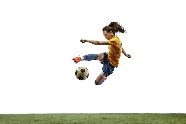 Photo female soccer player kicking ball at the stadium