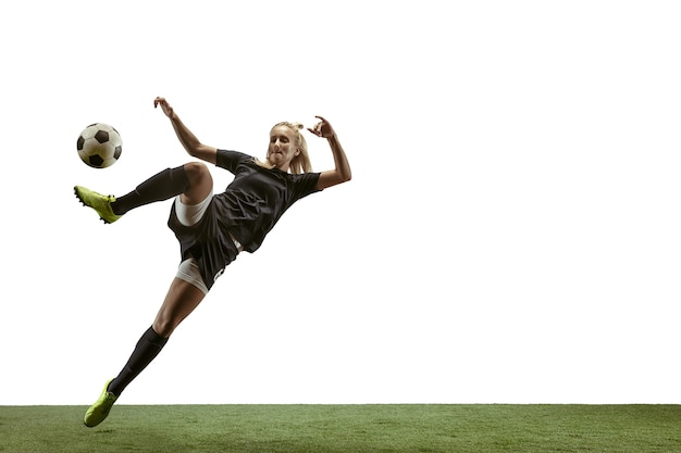 Photo female soccer player kicking ball at the stadium