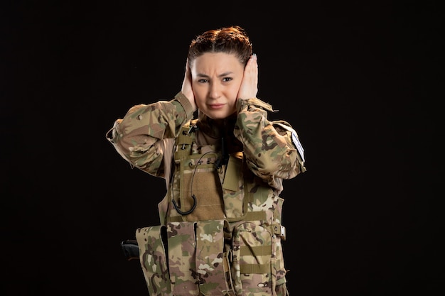 Фото Женщина-солдат в камуфляже на черной стене