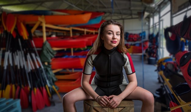 Female sportman in wetsuit, boats and diving gear. Boating rental or rescue station