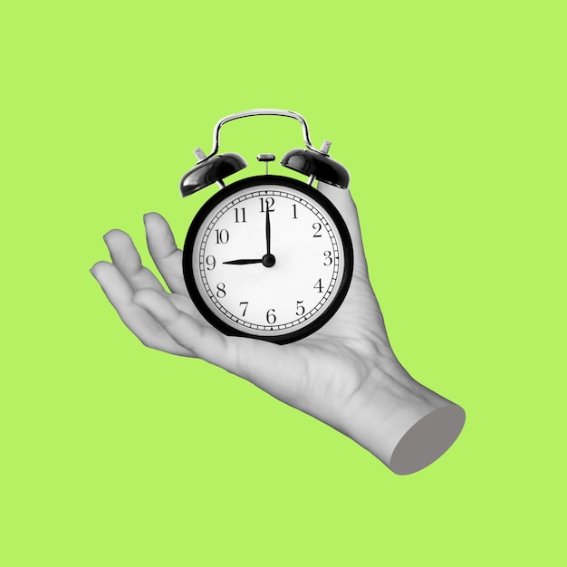 Female statues hand holding a black alarm clock isolated on light green color background 9 oclock