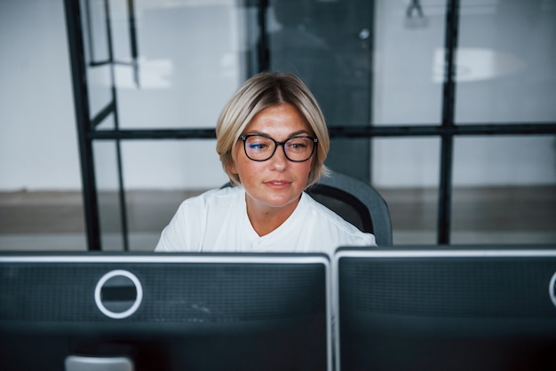 Female stockbroker in formal clothes works in the office with financial market.