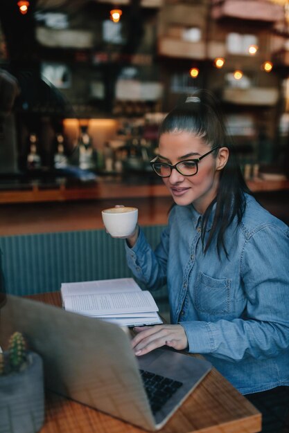 Female student at cafe learning with the help of technology