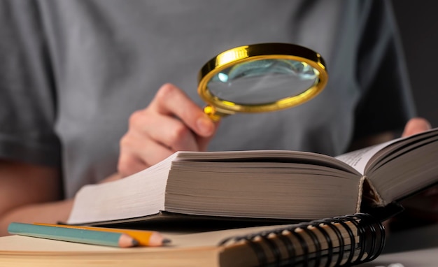 Le mani delle studentesse che tengono matita e libro di lettura, si preparano per l'esame a tavola di notte. concetto di educazione