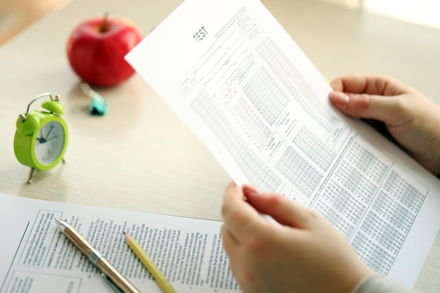 Female student hands testing in exercise and hold exam paper sheet with pencil at school test room