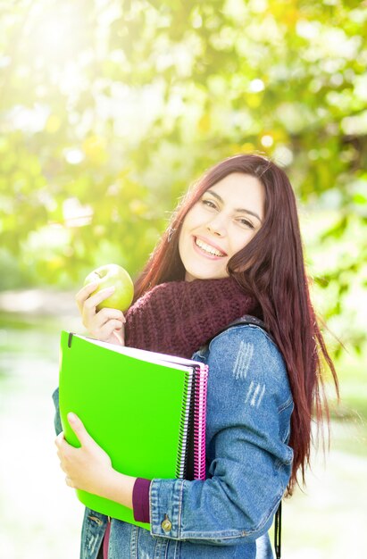 青リンゴを保持している女子学生。