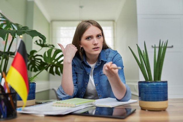 Female student looking talking to webcam studying German online