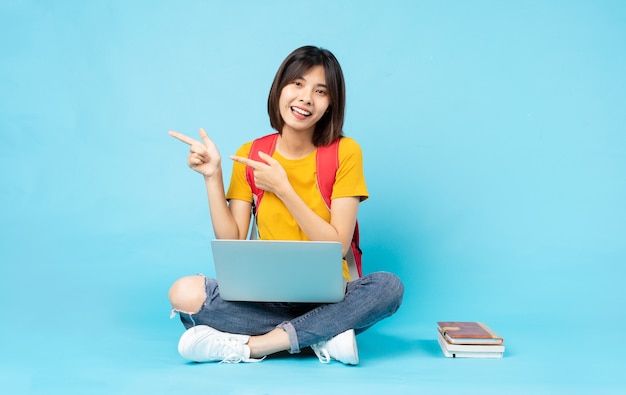 Female student portrait sitting on blue background ná»n