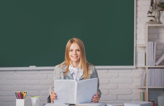 Female student reading book on lesson lecture in classroom at school college