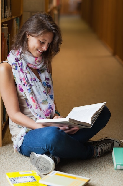 Photo female student reading a book in the library