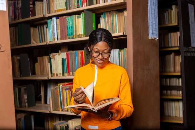 女性の学生、図書館で本を読む