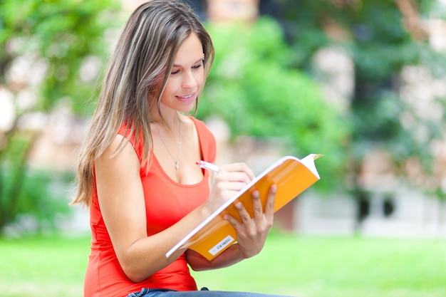 Female student reading a book at the park