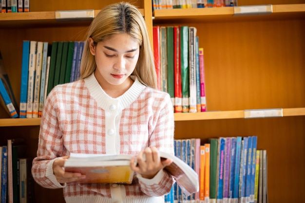 A female student reading a book at the university library