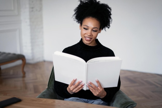 A female student reads a book documents a textbook at home