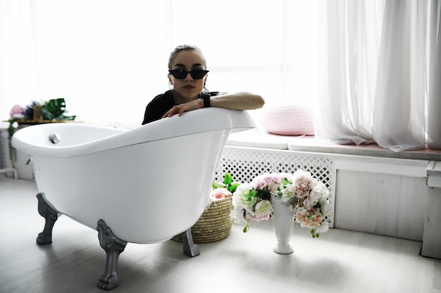 Female student in resting in the room Young stylish girl posing in the loft Blonde with glasses