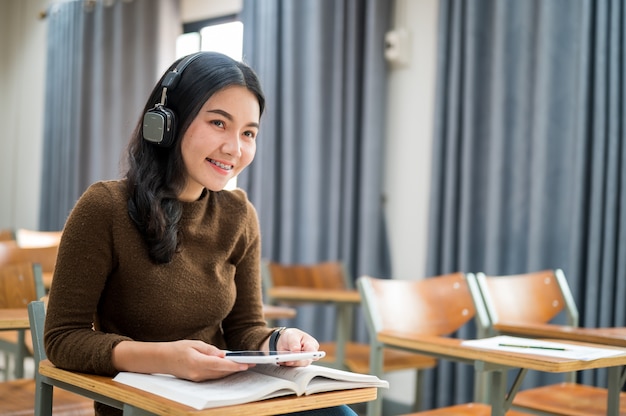 Female student sits and listen to music in the classroom