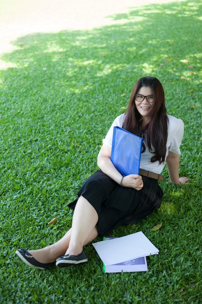 잔디밭에 앉아 여자 학생