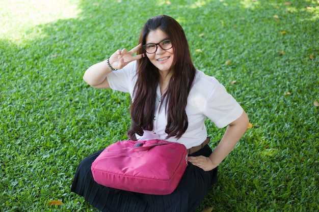 芝生に座っている女性の学生