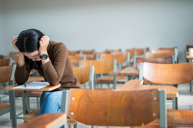 Una studentessa seduta in un'aula stressante