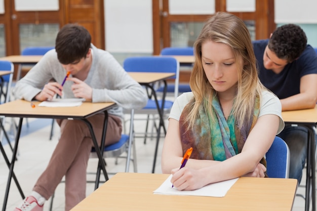 Photo female student sitting at table at the classroom