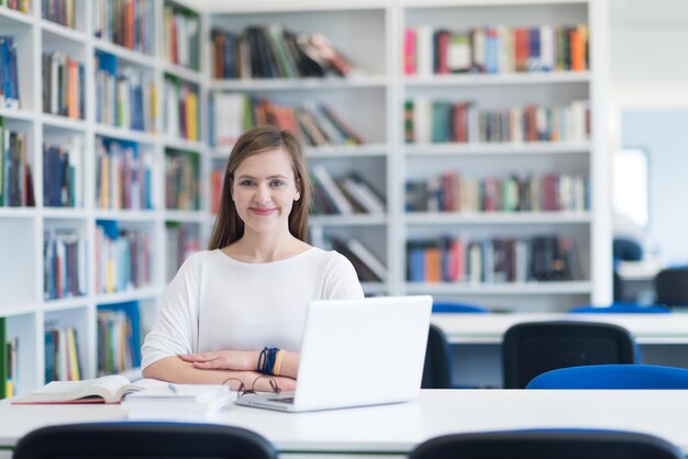 female student study in school library using laptop and searching for informations on internet