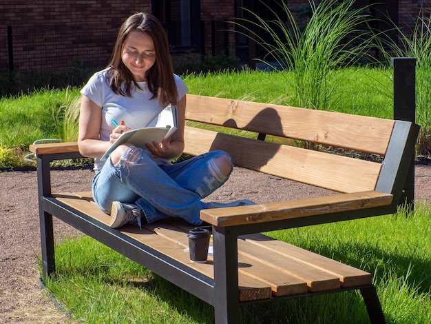 Female student studying on bench at campus