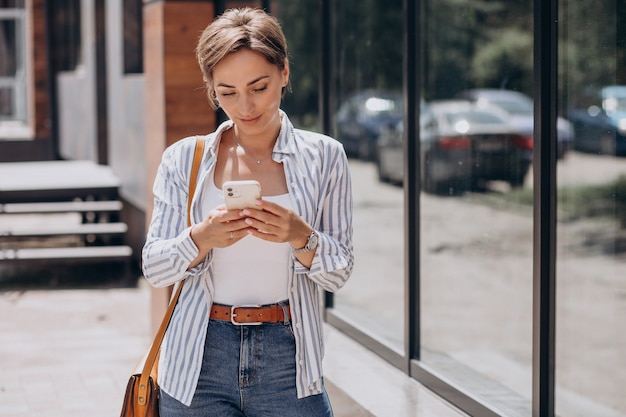 Female student using phone outside the street