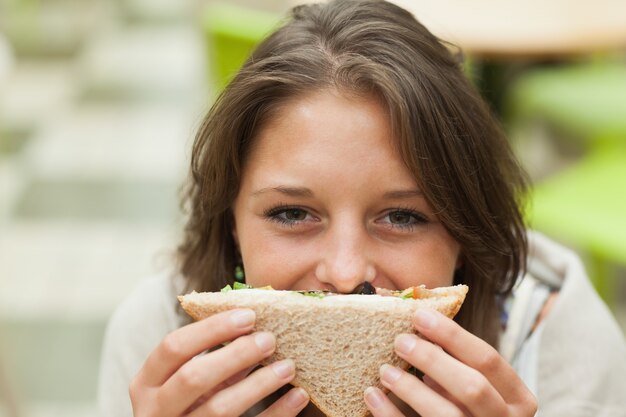 Photo female student with sandwich in the cafeteria