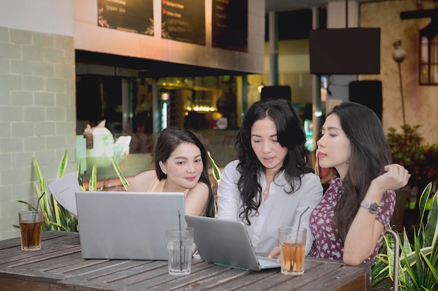 Студентки учатся с ноутбуком в кафе