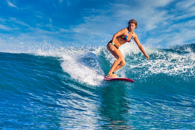 Photo female surfer on a blue wave at sunny day