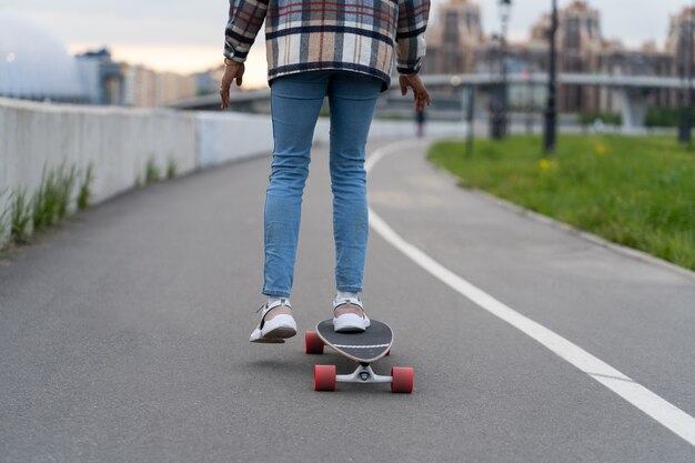 Female surfing city street on skateboard outdoors mixed race\
african casual woman riding longboard