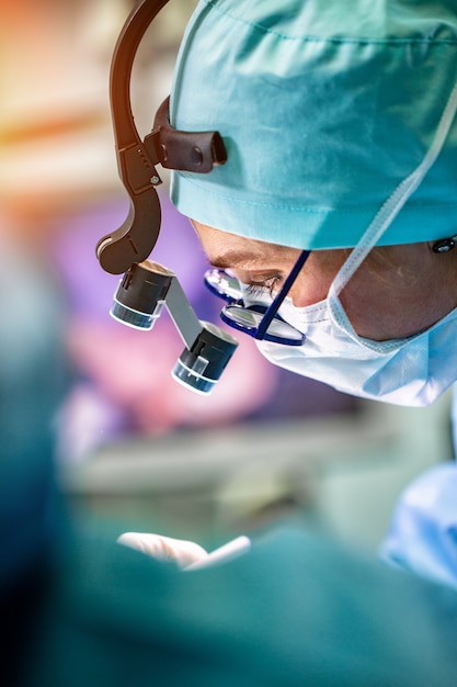 female surgeon doctor wearing protective mask and hat during the operation