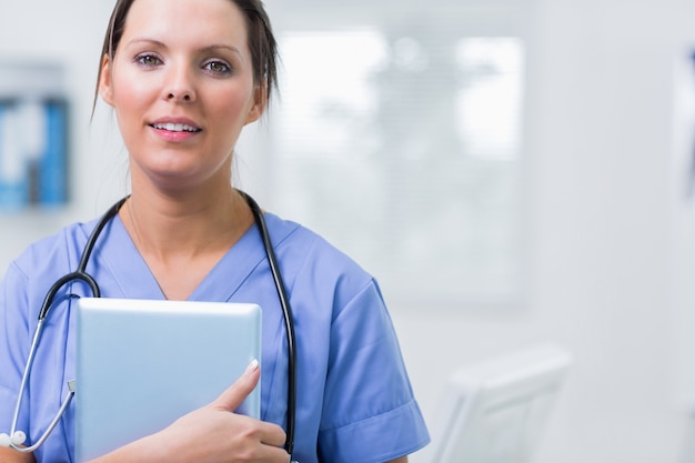 Female surgeon holding digital tablet at clinic