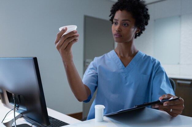 Photo female surgeon looking at medicine on desk in hospital