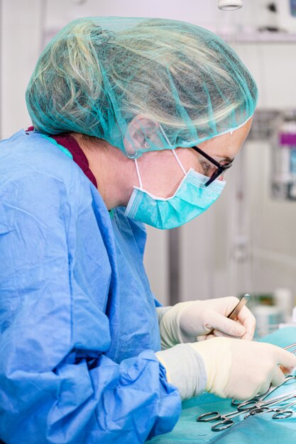 Female surgeon in operation room, operating a patient.