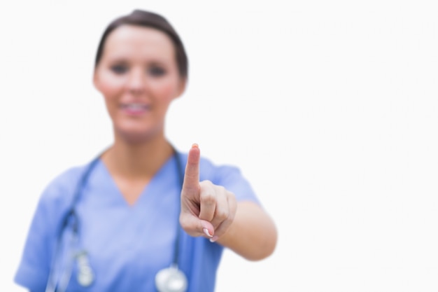 Female surgeon pointing on invisible screen