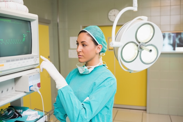 Chirurgo femminile che sta accanto ad un monitor