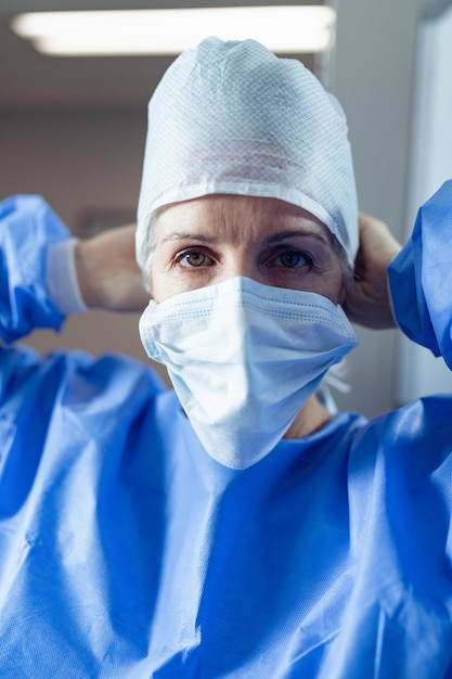 Female surgeon wearing surgical mask in operation theater at hospital