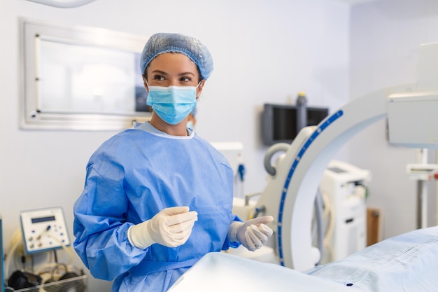 Chirurgo femminile con maschera chirurgica in sala operatoria utilizzando una macchina per chirurgia guidata da immagini 3d