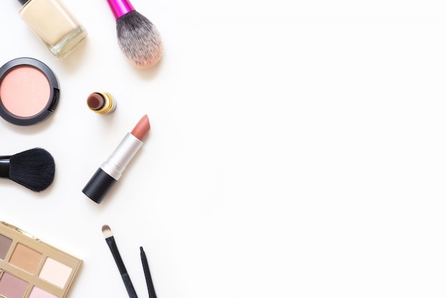 Photo female table with makeup including lipsticks, eye palette, foundation, brushes and others.