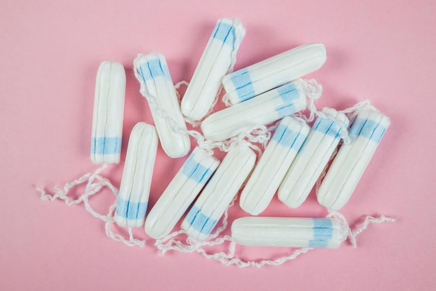 Foto tamponi femminili su sfondo rosa tampone bianco igienico per le donne tampone di cotone mestruazioni
