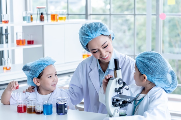 Female teacher experiments with children students in the laboratory
