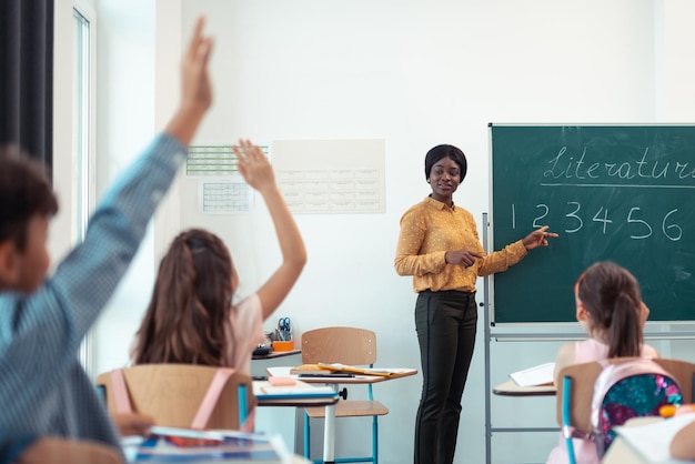 Female teacher giving the question for her smart pupils