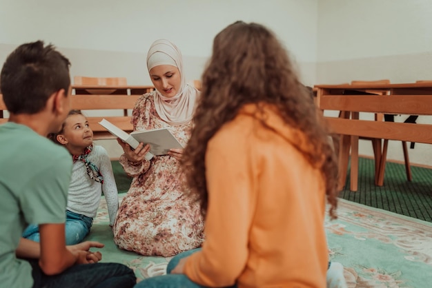 Female teacher helps school kids to finish their lesson They sitting all together on the floor Selective focus High quality photo