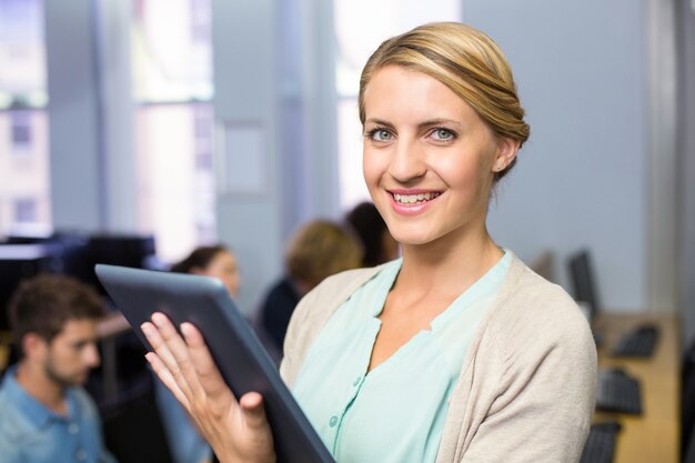 Female teacher using digital tablet in computer class