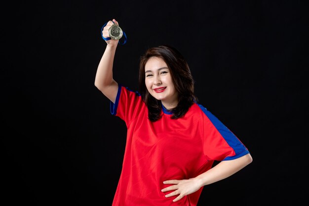 Female tennis player with st place medal on black