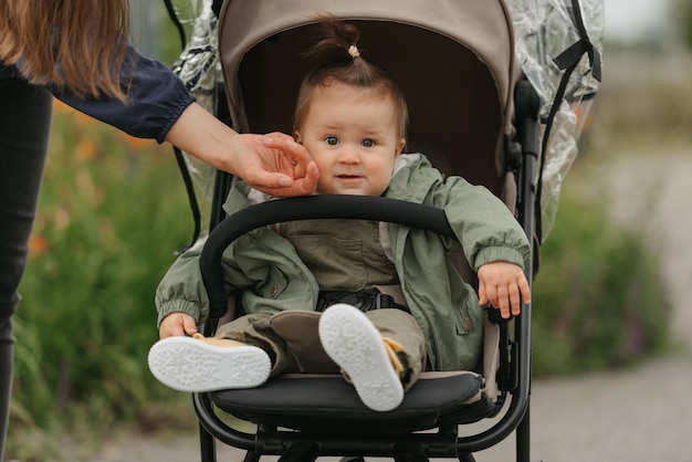 A female toddler is sitting in the stroller on a cloudy day